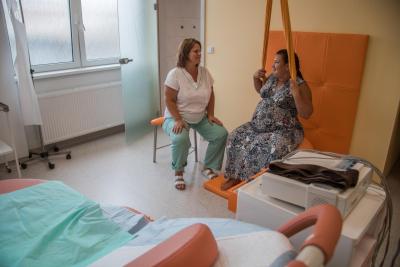 Porodnice Mulačova. Mulačova nemocnice, s.r.o., Gynekologicko-porodnické oddělení: Zdravotní asistentka pomáhající budoucí mamince s porodem.
