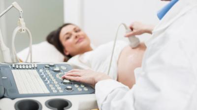 Lékař dělá těhotné ženě ultrazvukové vyšetření.