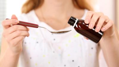 Žena dávkuje doplněk stravy femigard na lžičku. Podpora plodnosti a pravidelné menstruace.