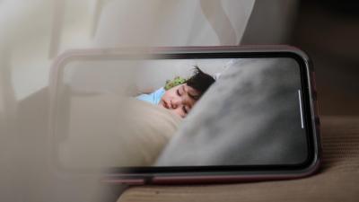 Dítě spící v postýlce - obrázek s monitorem dechu a chůvičkou.