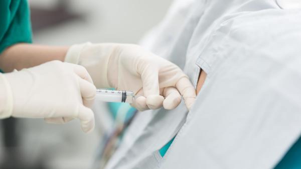 Doktor podává spinální anestézii pacientovi, císařský řez