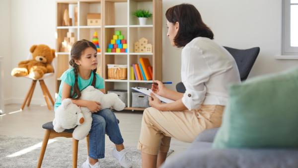 Dětská psycholožka mluví s dítětem. Diagnóza atypického autismu.