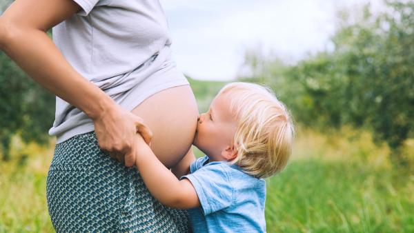 Chlapeček objímá těhotnou maminku a líbá ji na břicho, kdy je nutné provést císařský řez