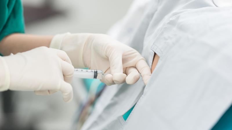 Doktor podává spinální anestézii pacientovi, císařský řez