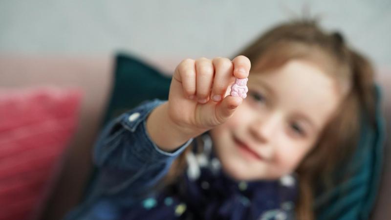 holčička s vitamíny Jamieson ve tvaru růžového medvídka