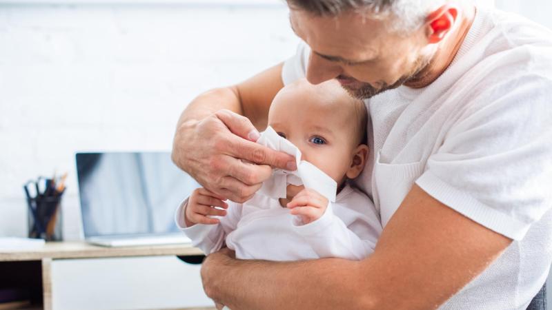 Tatínek utírá miminku nos kapesníkem, rýma u kojence