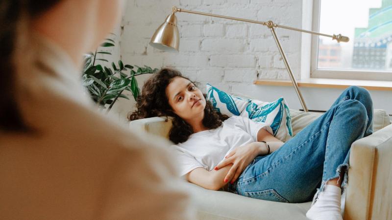 Dívka leží na terapeutickém gauči a poslouchá psycholožku, poruchy příjmu potravy