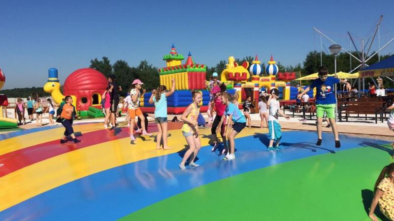 Velká trampolína plná skákajících dětí. Fajnpark.