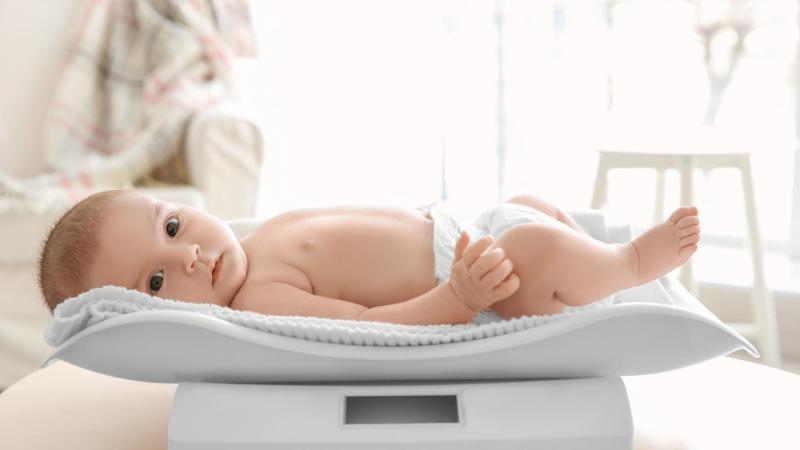 Miminko leží na novorozenecké váze, homeopatie u novorozenců