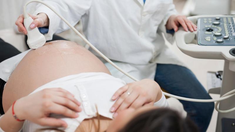Lékař dělá ultrazvuk těhotné ženě.