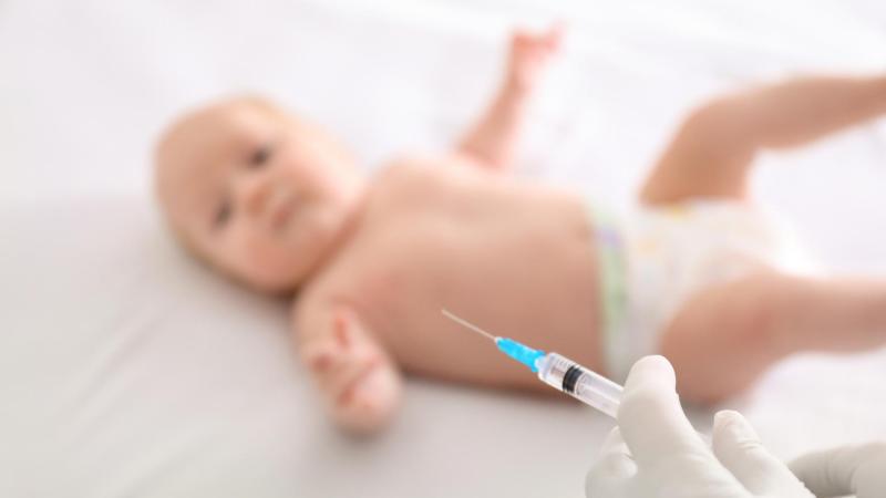 Malé miminko leží v nemocnici a čeká na dávku povinného očkování