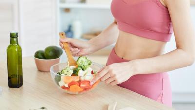 Žena mícha zeleninu v misce. Plodnost a vitamíny.