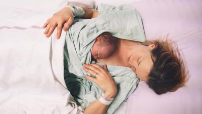 Matka drží čerstvě narozené miminko.