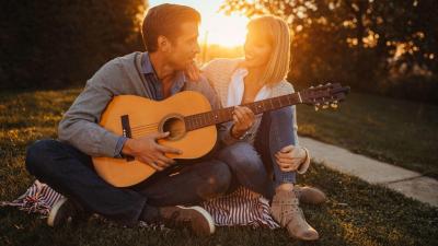 On a ona při západu slunce hrají na kytaru.