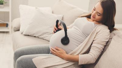 Těhotná žena poslouchá hudbu.