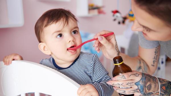 Maminka dává synovi sirup s odčervovacím účinkem.