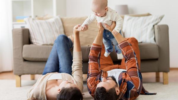 Maminka s tatínkem se hrají se svým adoptovaným dítětem.