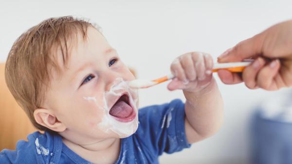Roční dítě snídá nízkotučný jogurt.