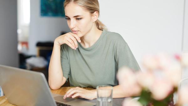 Žena sedí za počítaček a podává elektronickou žádost o přídavky na děti.