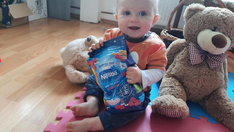 malý chlapeček s pytlíkem malinové kaše na dobrou noc od Nestlé