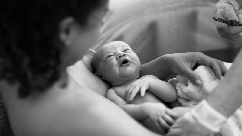 Žena drží v náručí své novorozené miminko.