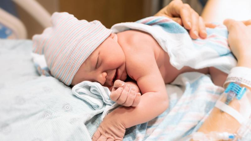Novorozené miminko leží na mamince hned po porodu.