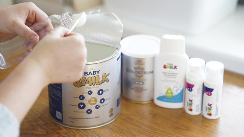 BABYSMILK, žena připravující umělé mléko pro dítě.