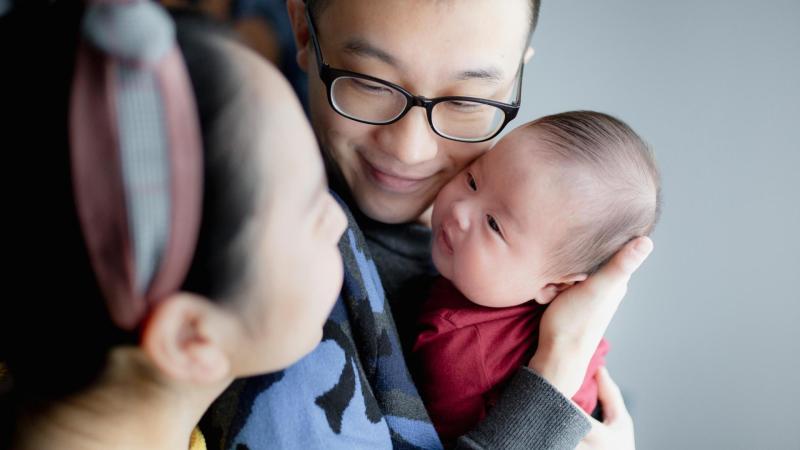 Maminka s tatínkem drží malého chlapečka v náruči, Čína
